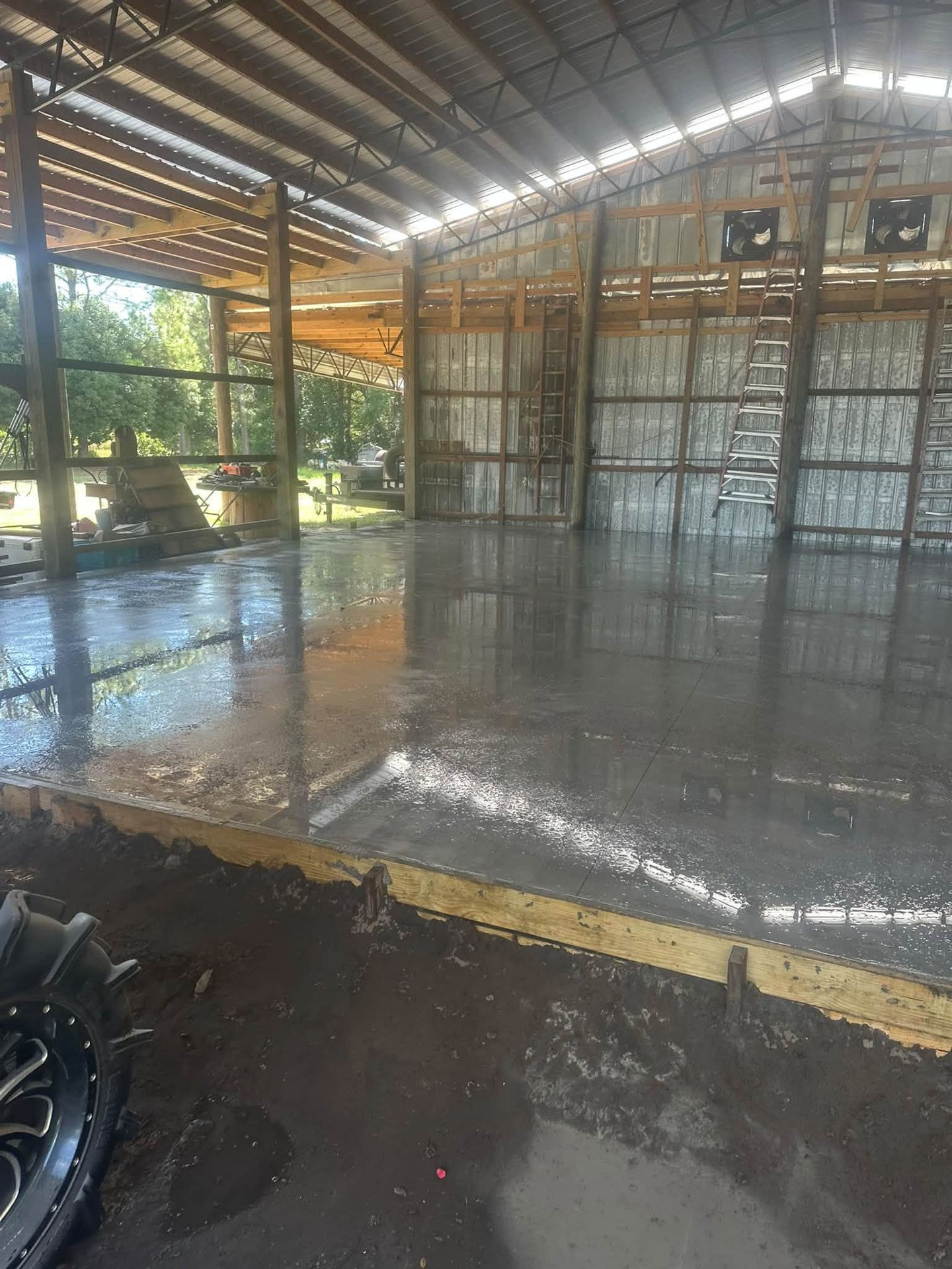 Freshly poured concrete floor inside a metal barn