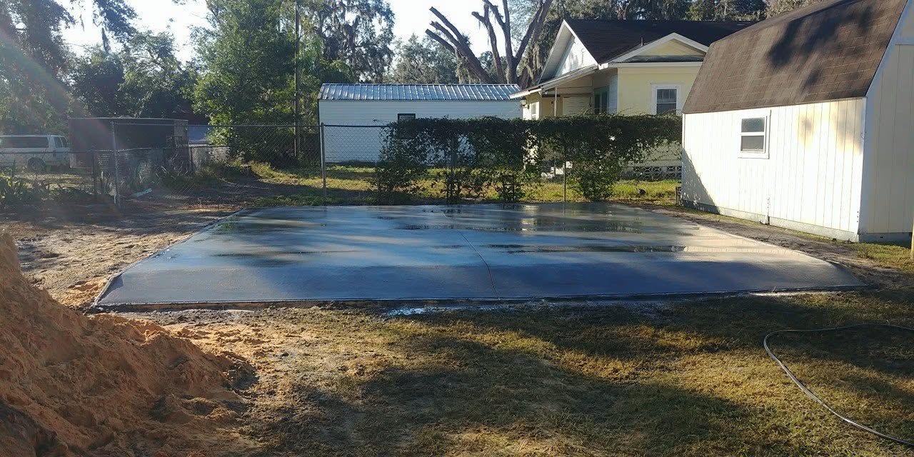 Freshly poured slab beside a shed