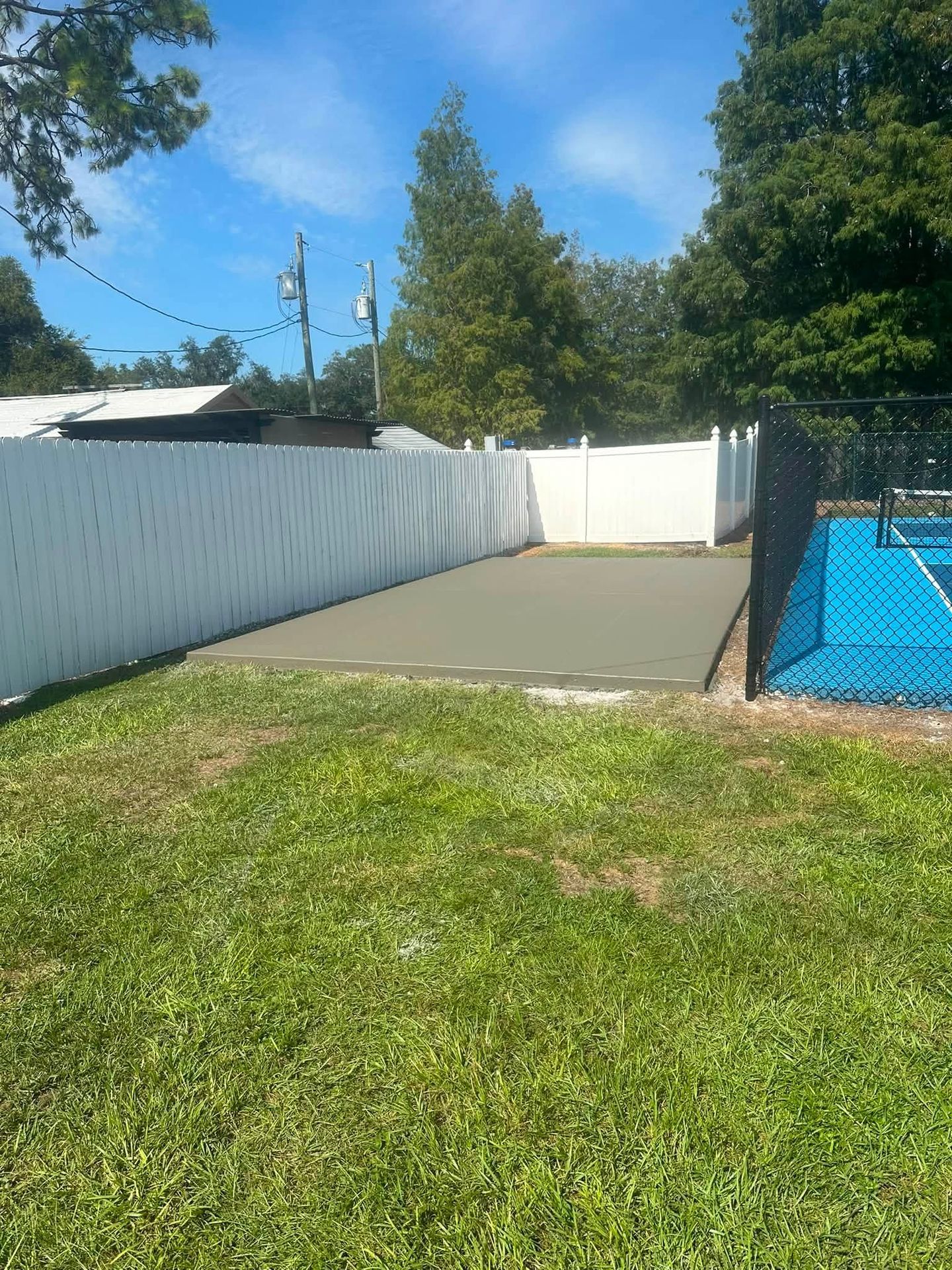 Concrete pool deck extension beside a screened pool